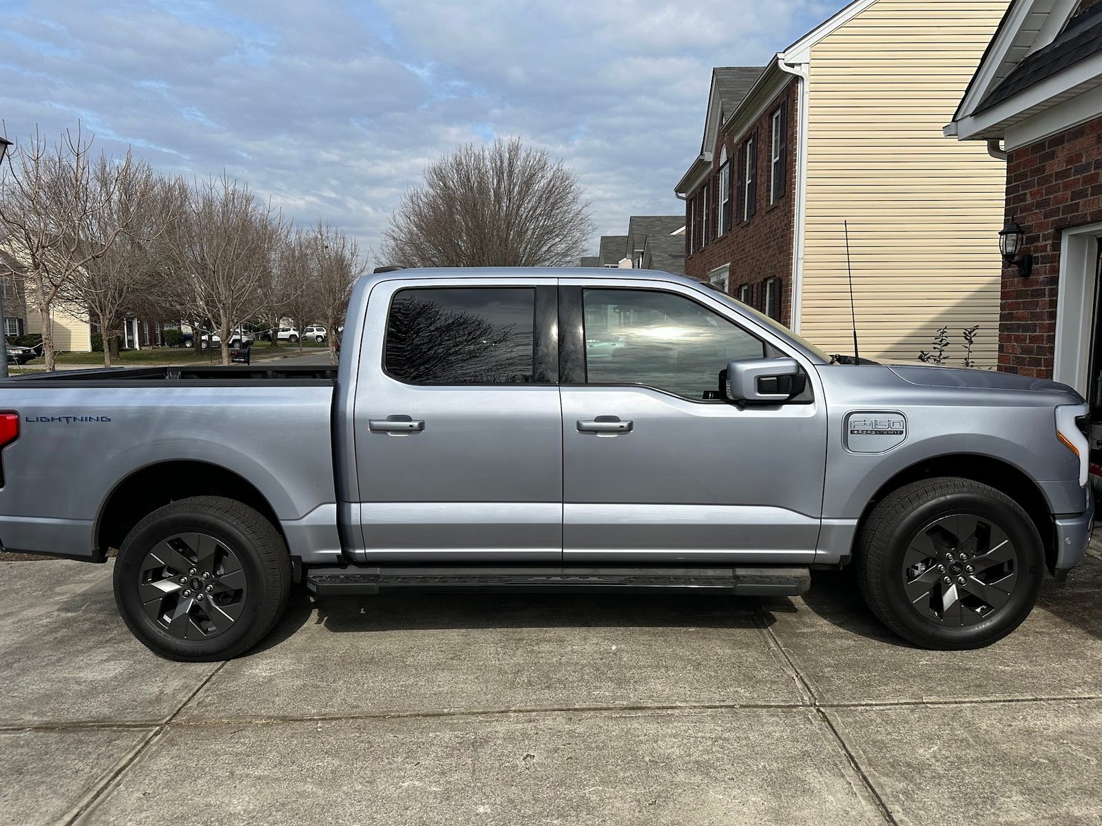 The Quiet Storm, a silver F-150 Lightning with dark Lariat wheels, parked in a driveway.